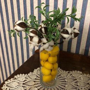 Cotton stem and greenery in lemon filled vase